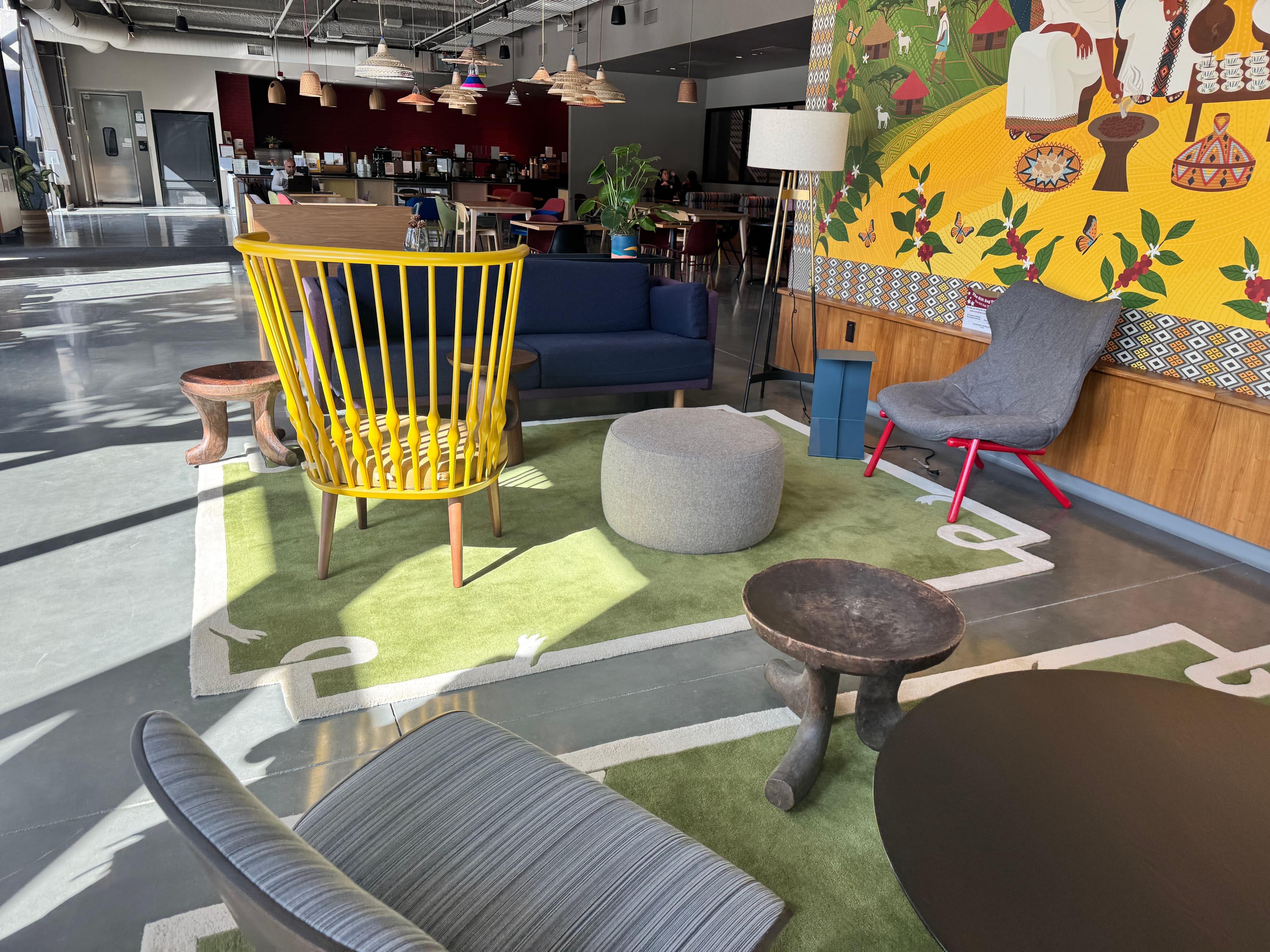 Open lounge area with colorful chairs and wall mural