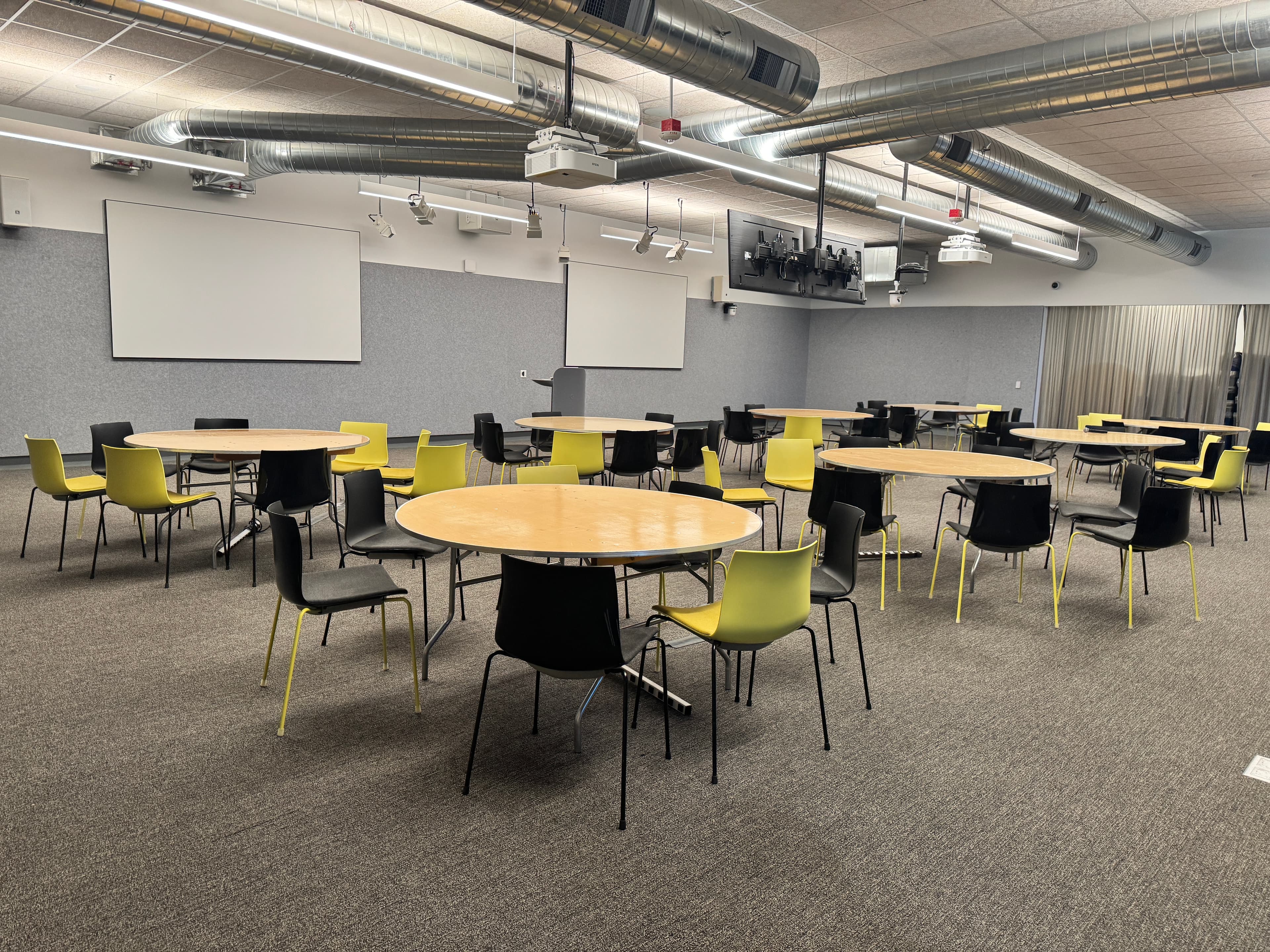 Main hall with round tables and chartreuse chairs