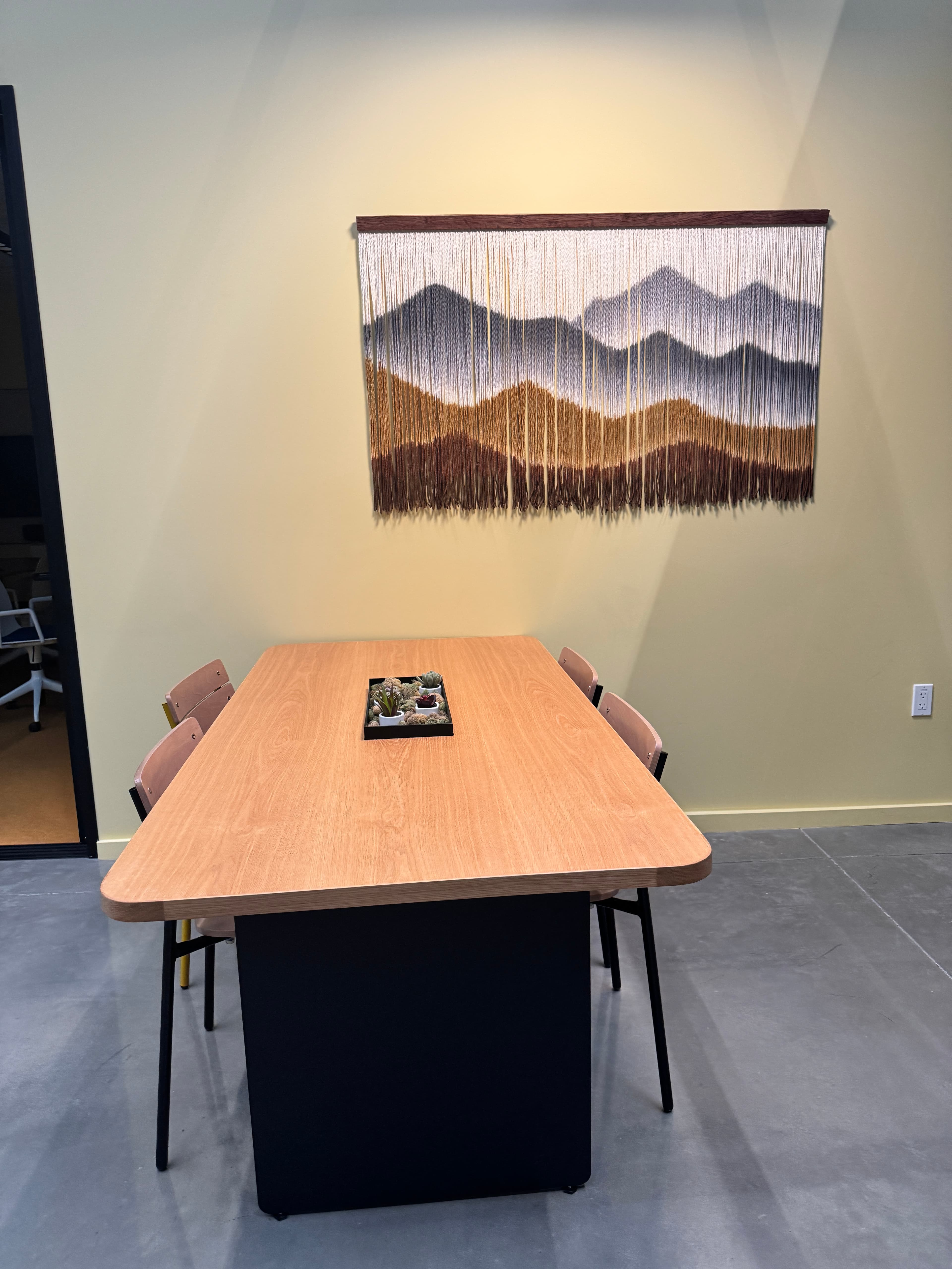 Seating in the atrium with fiber art wall hanging